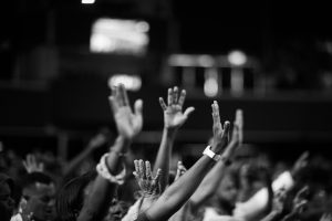 people with their hands up during a worship service